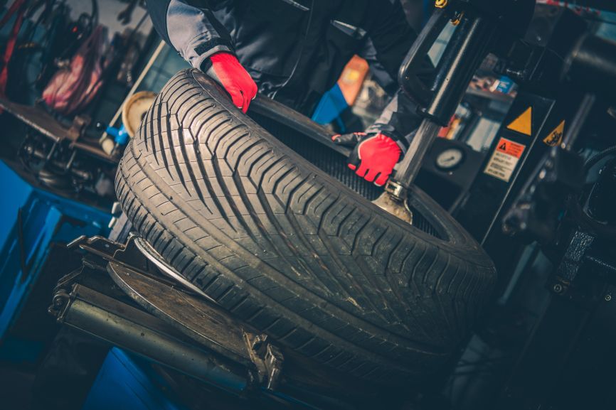 mechanic replaces tyre after a car failed mot inspection