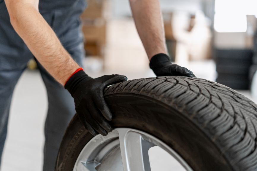 mechanic checks all season tyres for wear and condition